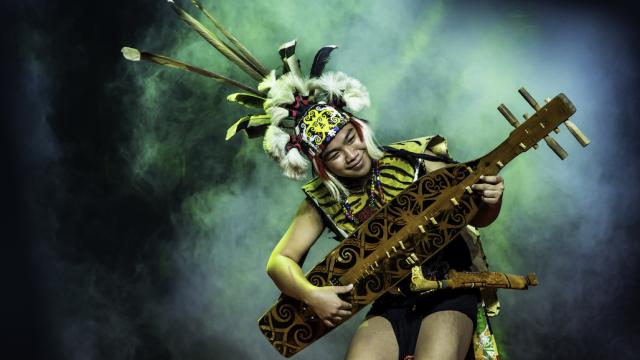 Man playing traditional musical instrument sape.