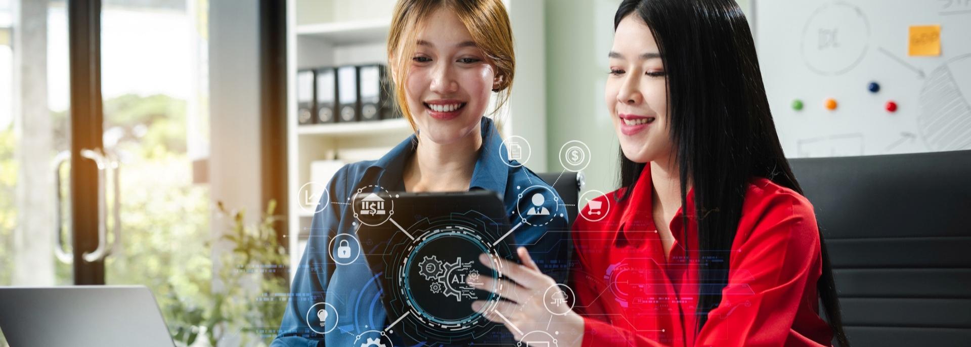 Two women using a computer tablet. Photo credit: iStock.